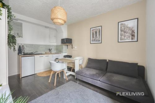 un salon avec un canapé et une cuisine dans l'établissement Flexliving - Onebedroom - Mademoiselle, à Paris