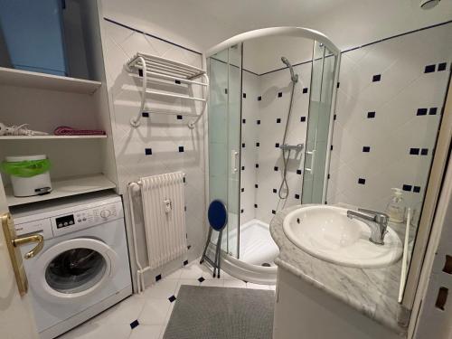 une salle de bain avec une machine à laver et un lavabo dans l'établissement Le Pacifique 6 Pers RDC face a la Mer, à Le Touquet-Paris-Plage