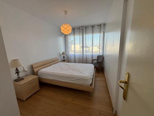 une petite chambre avec un lit et une fenêtre dans l'établissement Le Pacifique 6 Pers RDC face a la Mer, à Le Touquet-Paris-Plage