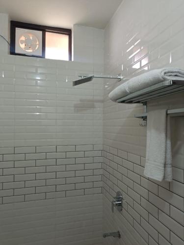 a white tiled shower with a window in a bathroom at hotel saanjh haveli in Orchha