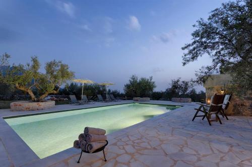 a swimming pool with chairs and a table at Ethos Retreat, Luxury Villas in Areopolis