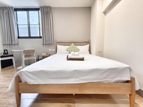 a bedroom with a large bed with white sheets at Lin's House in Ch'ih-k'an-lou