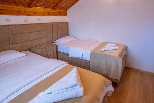 a room with two beds with towels on them at Hotel Pavlović in Žabljak