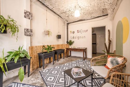 a room with potted plants and a table at L'Amarillo Clim Wifi Centre ville 4 pers in Lézignan-Corbières