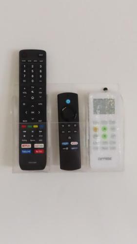 a group of three remote controls sitting on a shelf at Comfortable and Centrally Located Accommodation in Altamira