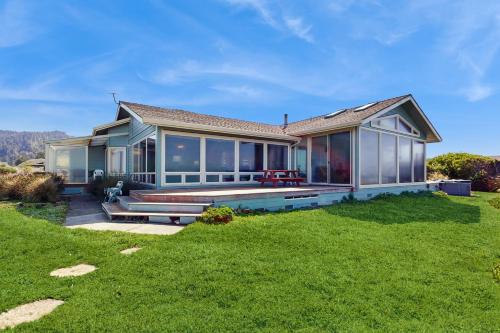 una casa con ampie finestre e un prato di Misty Rose a Fort Bragg