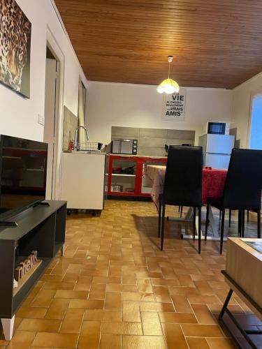un salon avec une table et une cuisine dans l'établissement Maison proche du lac, à Priziac