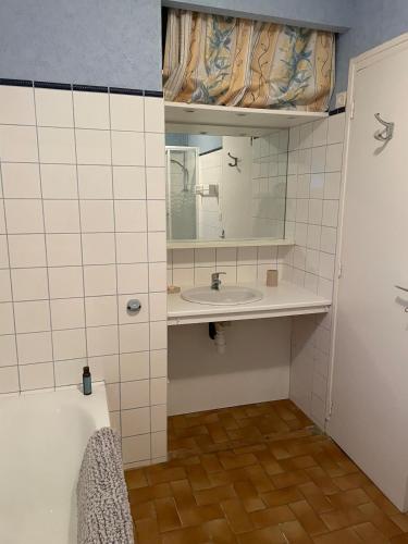une salle de bain avec un lavabo et un miroir dans l'établissement Maison proche du lac, à Priziac