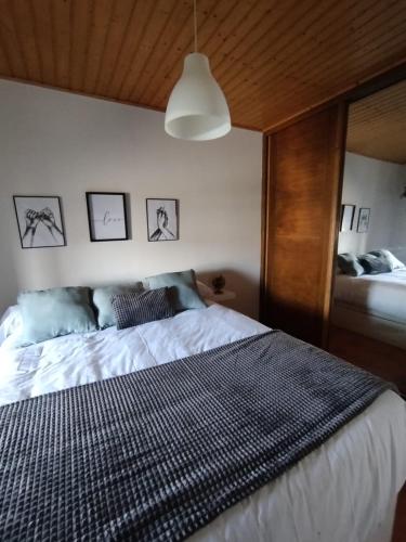 a bedroom with a large bed with a wooden ceiling at A Casiña de Rande in Redondela