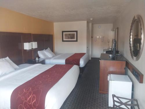 a hotel room with two beds and a television at Vermilion Inn in Kanab