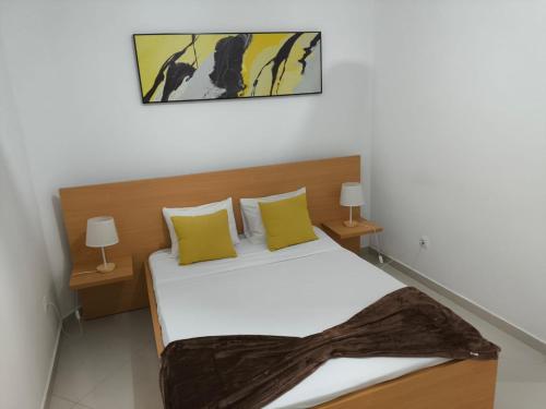 ein Schlafzimmer mit einem Bett mit gelben Kissen in der Unterkunft Catedral View Apartment in Cidade Velha