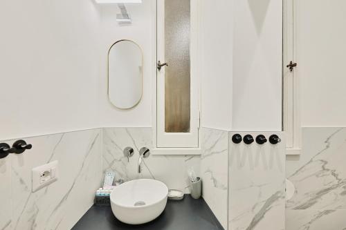 a white bathroom with a toilet and a mirror at Casa di borgo in Rome