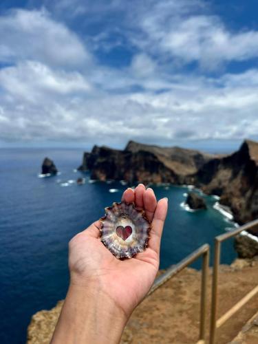 a hand holding a donut in front of the ocean at Villa-Kasia Ocean View Studios in Caniço