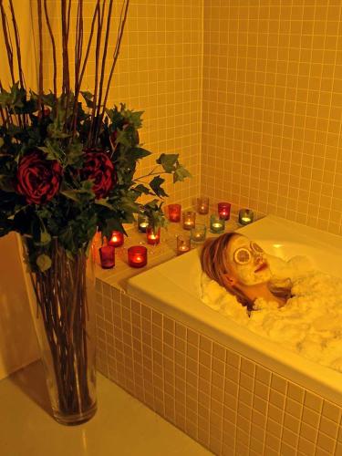 un vase de roses et des bougies dans une salle de bain dans l'établissement Chalet Broski - Luxury near St Martin De Bellville, à Planvillard