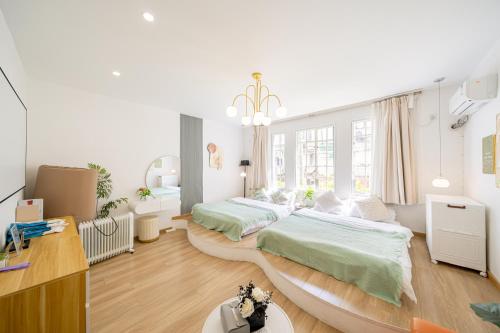 a bedroom with two beds and a desk at 柃居 B&B - Jing'an Temple Branch in Shanghai