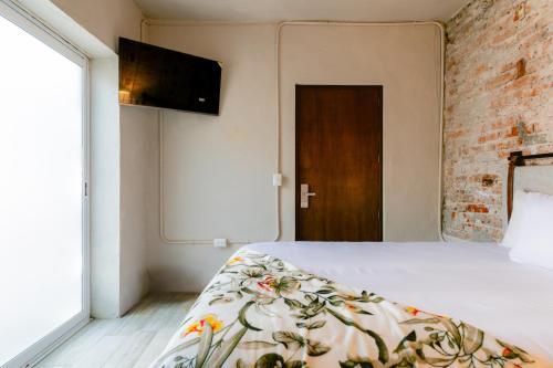 a bedroom with a bed and a television on a wall at Casa Xaca in San Miguel de Allende