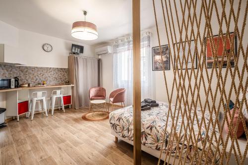 une chambre avec un lit et une cuisine avec une table dans l'établissement Studio Marceau Clim Wifi Centre ville 2 pers, à Lézignan-Corbières