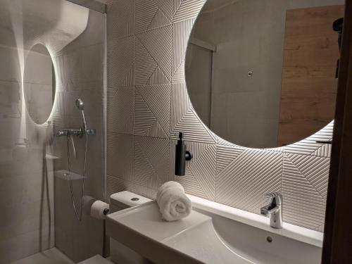 a bathroom with a shower and a sink and a mirror at Kalea Elysivm in Alcalá del Júcar