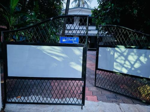 two signs on a fence in front of a building at Bluebell Home in Kozhikode