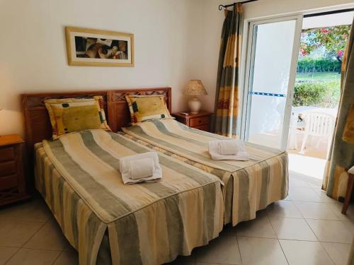 a bedroom with a bed with two towels on it at Balaia Golf Village T2 a 10 minutos da praia in Olhos de Água