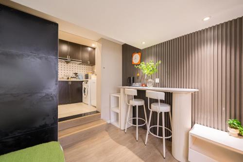 a kitchen with a bar with stools in a room at 柃居 B&B - Jing'an Temple Branch in Shanghai
