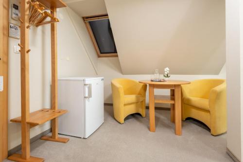 a small room with a table and chairs and a refrigerator at Vila Sofia in Tržič