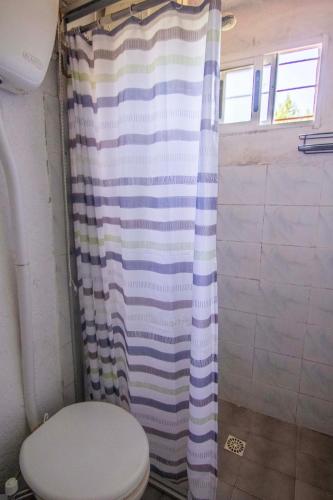 a bathroom with a toilet and a shower curtain at Casa Dibar in La Pedrera