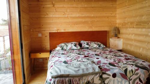 a bedroom with a bed with a wooden wall at Recanto Terra Alta in São Roque do Pico