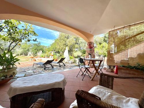 an outdoor patio with chairs and a table and a table at Colori di Sardegna Apartments in Bari Sardo