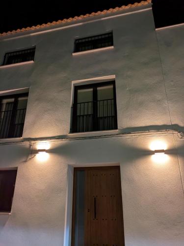 a white building with two windows and a door at Kalea Elysivm in Alcalá del Júcar