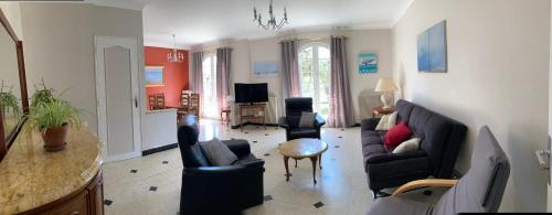 un salon avec un canapé, des chaises et une table dans l'établissement villa Moana andernos, à Andernos-les-Bains