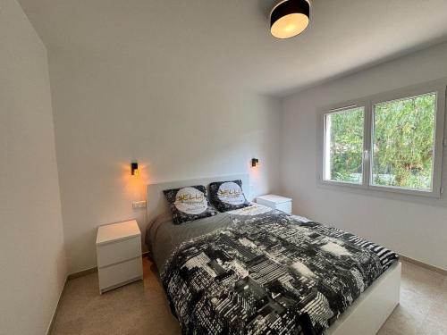 Sainte-Maxime appartement 45m avec jardin de 35m في سانت ماكسيم: غرفة نوم بها سرير ونافذتين