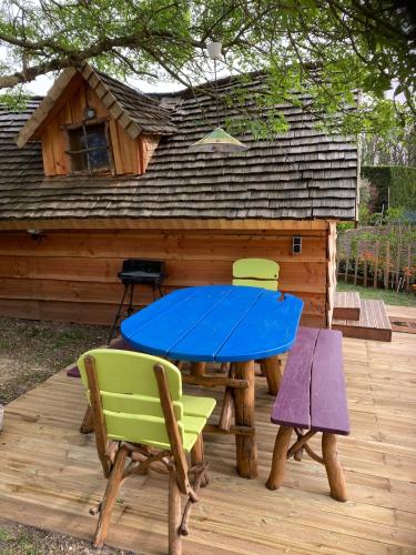 - une table de pique-nique et des chaises en face d'une cabine dans l'établissement Cabane insolite entre Albi et Cordes-sur-ciel, à Sainte-Croix