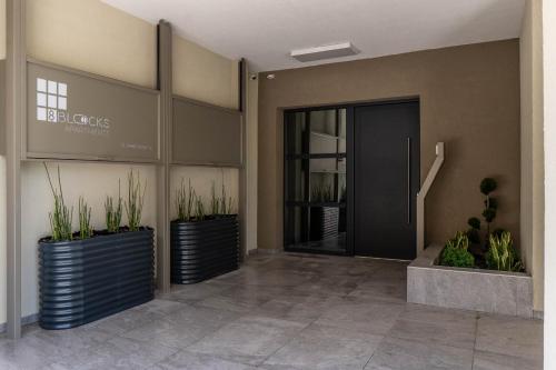 a lobby of a building with a door and plants at 8 Blocks Apartments in Alexandroupoli