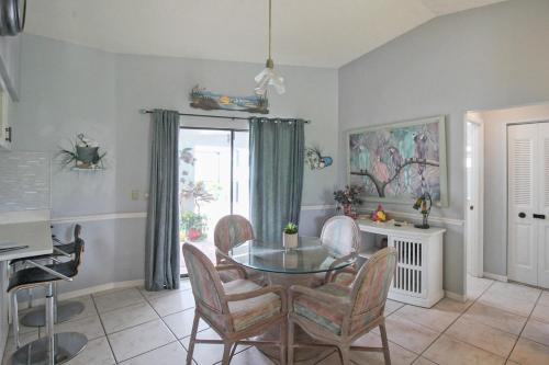 a dining room with a glass table and chairs at Enjoy Family Fun In This 2BR 2BA Englewood Pool Home in Englewood