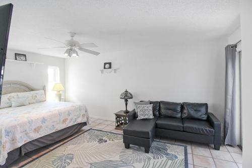 a bedroom with a bed and a black leather chair at Enjoy Family Fun In This 2BR 2BA Englewood Pool Home in Englewood