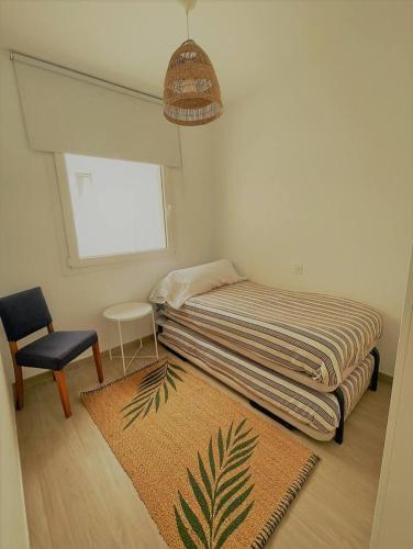 a small bedroom with a bed and a chair at Sunset Bastián, junto a la costa in Costa Teguise