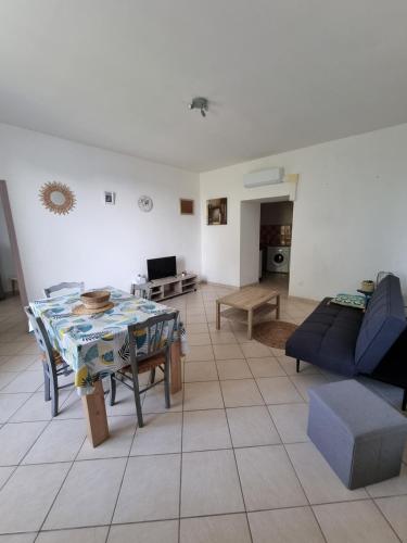 un salon avec une table et un canapé dans l'établissement Appartement 1 chambre, à Sartène