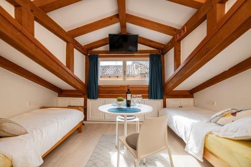 ロヴィニにあるAntiche Muraのテーブルと窓のある部屋にベッドが2つある