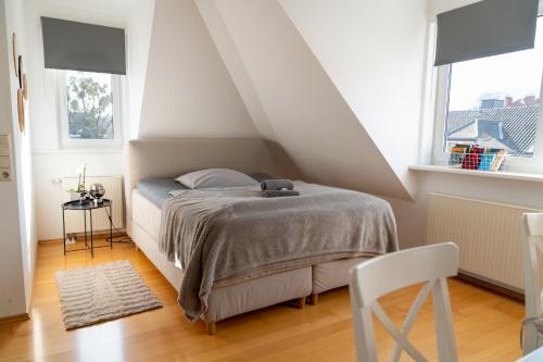 a bedroom with a bed and two windows at BRIGHT by Interior Apartments in Kassel