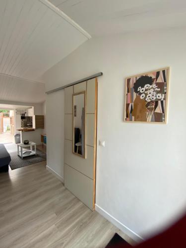 un salon avec une porte et un tableau sur le mur dans l'établissement Le Farniente, à Canet