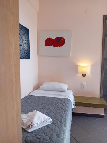 a bedroom with a bed and a picture on the wall at Heliotopos Apartments in Tolo