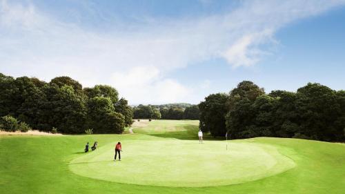 a group of people playing golf on a golf course at Mottram Hall in Macclesfield
