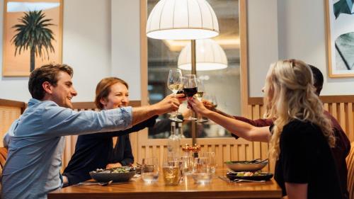 a group of people sitting around a table drinking wine at Mottram Hall in Macclesfield