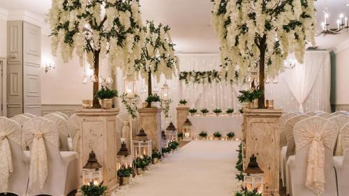 a wedding ceremony aisle with chairs and flowers at Mottram Hall in Macclesfield
