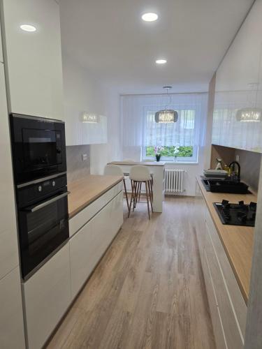 a kitchen with white cabinets and a counter top at Apartmán Mária in Bardejov