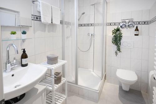 a white bathroom with a sink and a shower at hygge-flats Apartment für 2-6, WLAN, Homeoffice in Heppenheim an der Bergstrasse