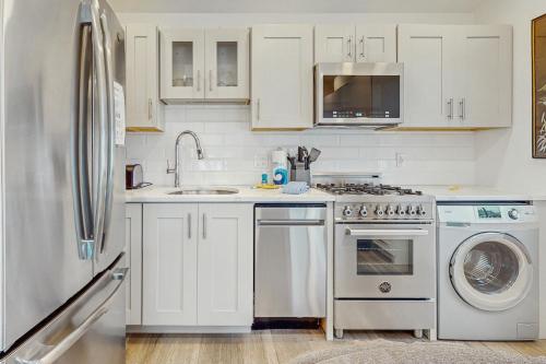 a white kitchen with a sink and a refrigerator at Provincetown Paradise in Provincetown