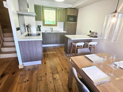 une cuisine et une salle à manger avec une table et des chaises dans l'établissement Appartement triplex au calme proche centre, 3 chambres, 6 pers, cheminée, parking couvert, WiFi - FR-1-598-53, aux Gets