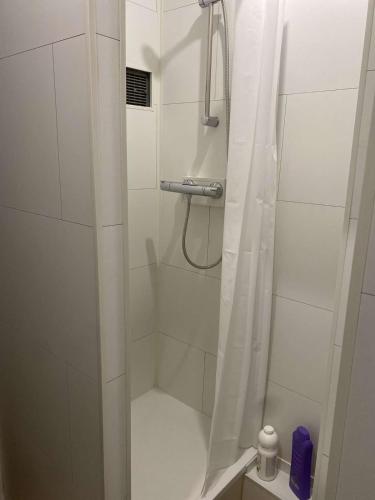 La salle de bains est pourvue d'une douche blanche avec rideau de douche. dans l'établissement La Douce Escale, Toulon Hyper Centre, à Toulon